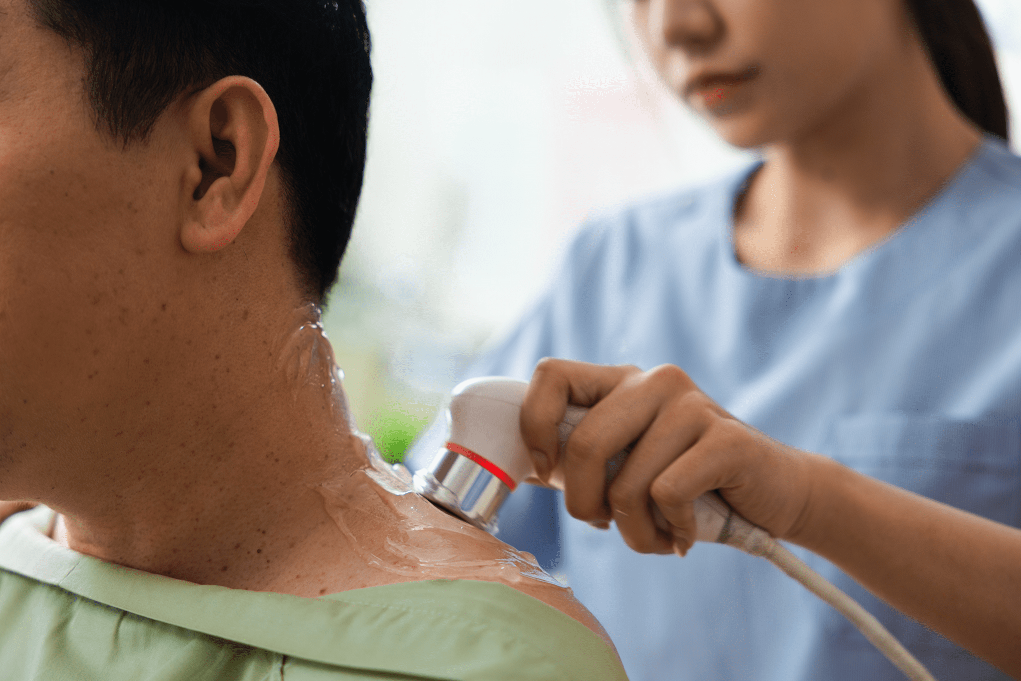 A person receives a neck massage with a handheld massager.