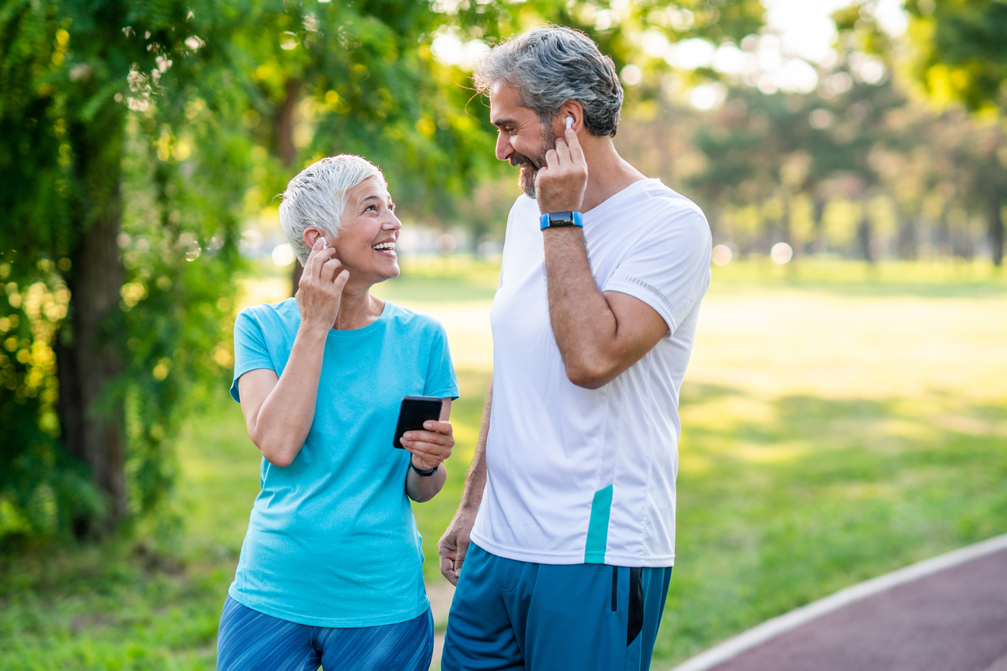 Elderly couple enjoying a walk and coffee outdoors.