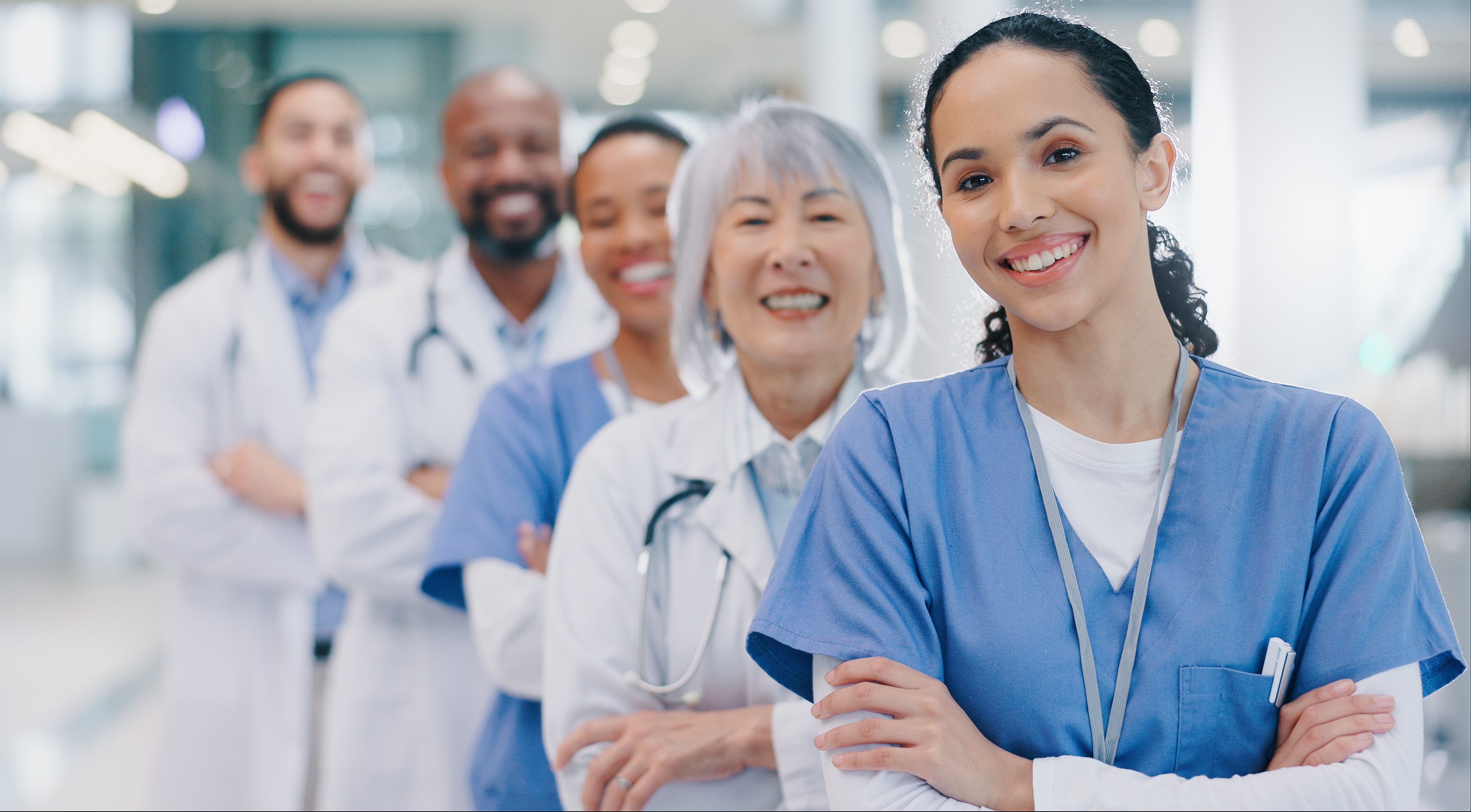 Diverse healthcare team smiling confidently in hospital uniforms.
